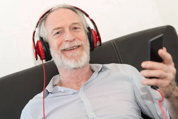 Moderno hombre maduro escuchando música en el teléfono móvil —  Fotos de Stock