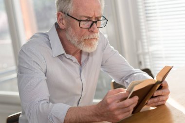 Kitap okuyan olgun bir adam.