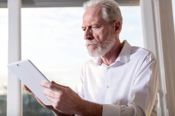 Senior affärsman med en digital tablett, hårt ljus — Stockfoto