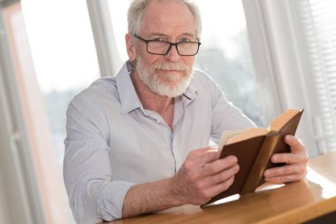 Kitap okuyan olgun bir adam.