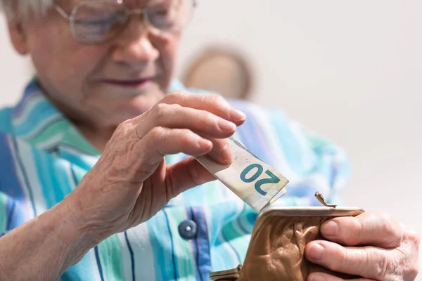 Mujer mayor sacando un billete de su billetera — Foto de Stock