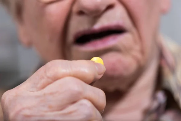 Old woman taking medication — Stock Photo, Image