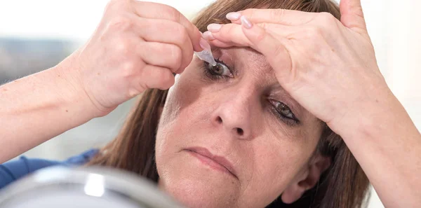 Женщина закапывает глазные капли в глаз — стоковое фото