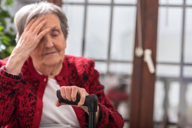 Baş ağrısı olan yaşlı bir kadın.