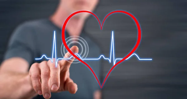Człowiek, dotykając serce bije wykres na ekranie dotykowym — Zdjęcie stockowe