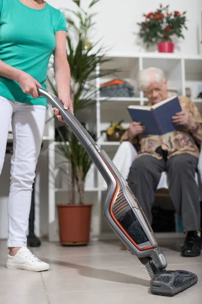 Ayudante de hogar aspirando para una anciana —  Fotos de Stock
