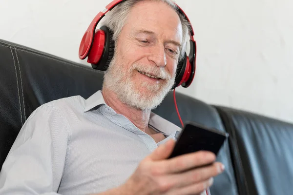 Moderna mogen man lyssnar musik på mobiltelefon — Stockfoto