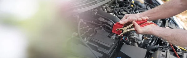 Manos del mecánico de coche usando cable de puente de batería de coche —  Fotos de Stock