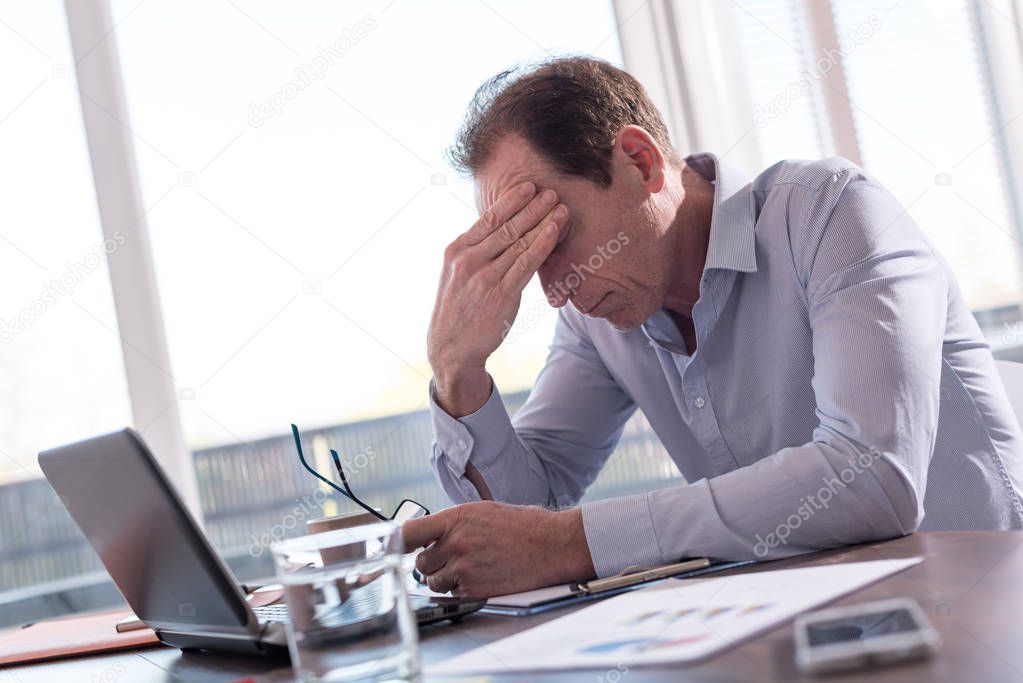 Stressed businessman sitting in office