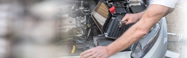 Mecánico usando el ordenador portátil para comprobar el motor del coche —  Fotos de Stock