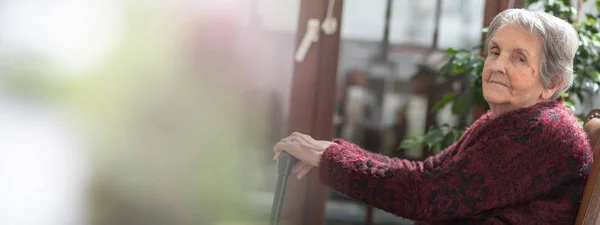 Vieja con las manos en un bastón — Foto de Stock