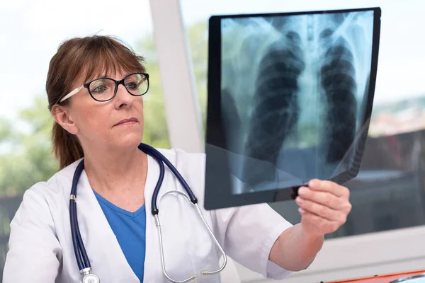 Ärztin untersucht Röntgenbericht — Stockfoto