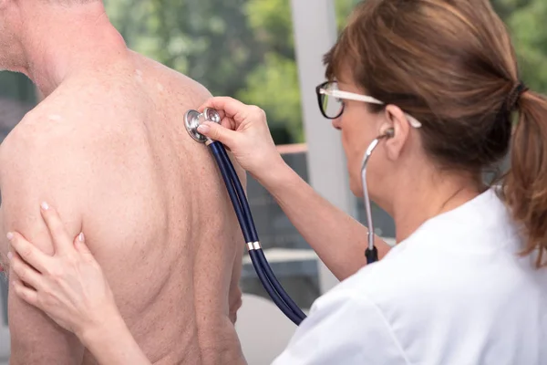 Médico usando estetoscópio para examinar o paciente — Fotografia de Stock