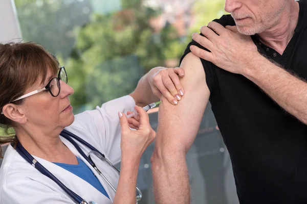 Doctora vacunando a un hombre — Foto de Stock