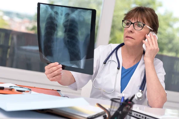 Médica examinando relatório de raio-x — Fotografia de Stock