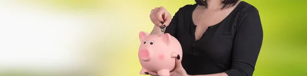 युवा महिला सूअर बैंक में सिक्का डाल रही है — स्टॉक फ़ोटो, इमेज