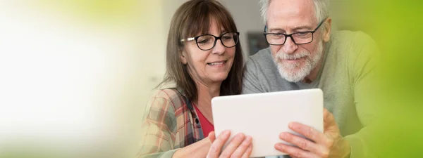 Modern mature couple using tablet — Stock Photo, Image