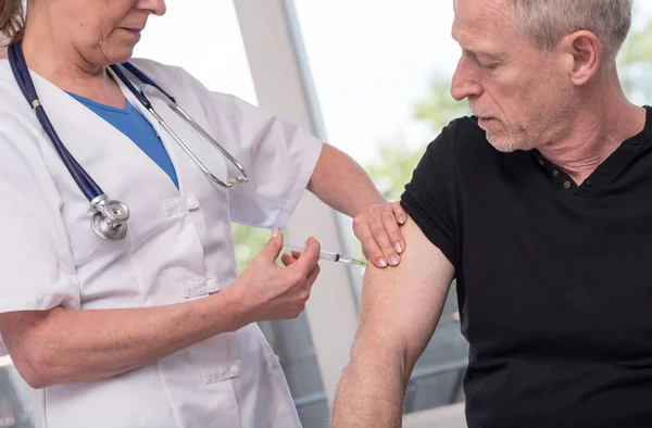 Médica a vacinar um homem — Fotografia de Stock