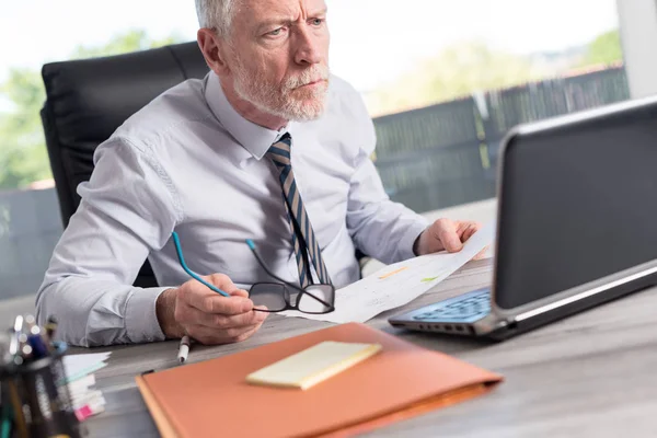 Reifer Geschäftsmann arbeitet am Laptop — Stockfoto