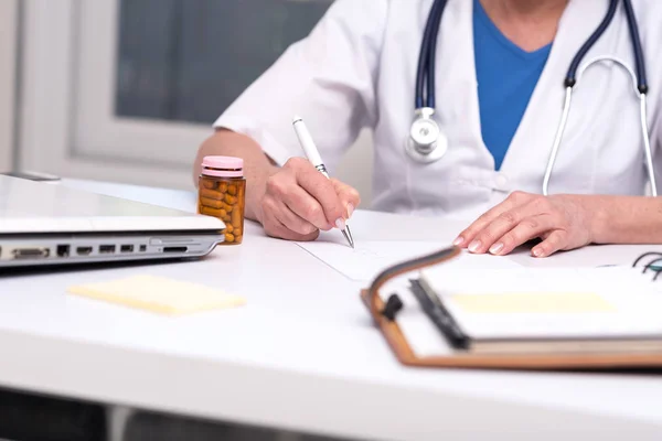 Female doctor writing prescription