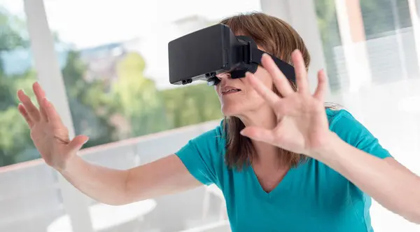 Mulher usando um fone de ouvido de realidade virtual — Fotografia de Stock