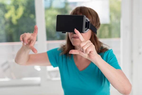 Mulher usando um fone de ouvido de realidade virtual — Fotografia de Stock