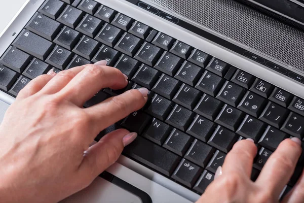 Eller dizüstü bilgisayarda klavyede yazıyor.