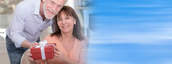 Mature couple with gift box — Stock Photo, Image