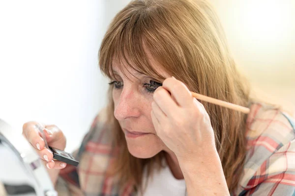Woman applying eyeshadow powder, light effect — Stock Photo, Image