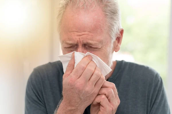 Man blowing his nose, light effect