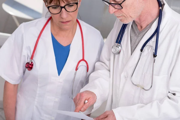 Два врача обсуждают медицинский отчет — стоковое фото