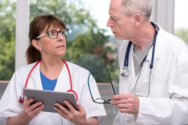 Δύο γιατροί συζήτηση σχετικά με την ιατρική έκθεση στο tablet — Φωτογραφία Αρχείου