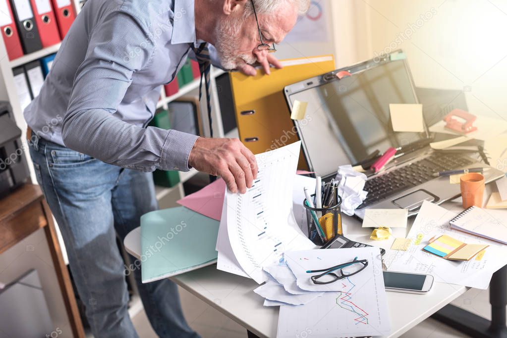 Disorganized businessman looking for documents, light effect