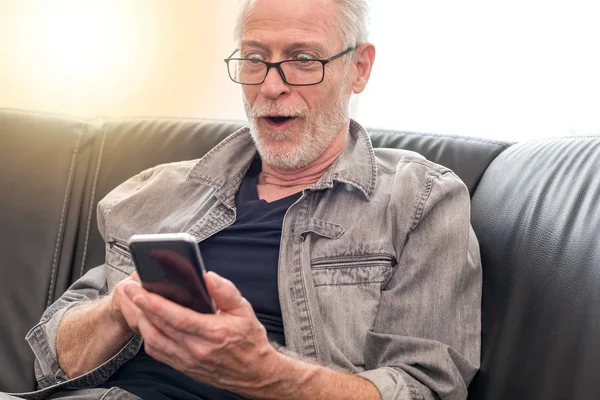 Förvånad man tittar på sin mobil telefon, ljuseffekt — Stockfoto