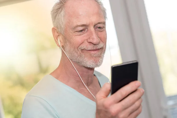 Portret van een volwassen man luisteren muziek met koptelefoon, lichte EVF — Stockfoto