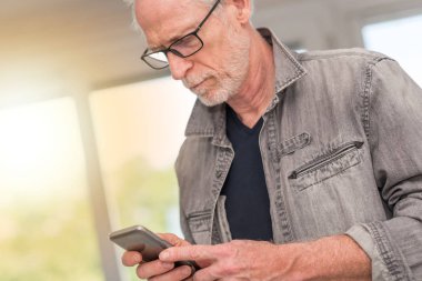 Olgun adam onun telefon, ışık efekti kullanarak portresi