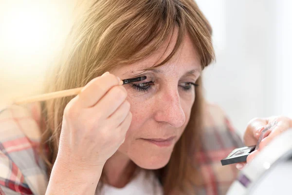 Woman applying eyeshadow powder, light effect — Stock Photo, Image