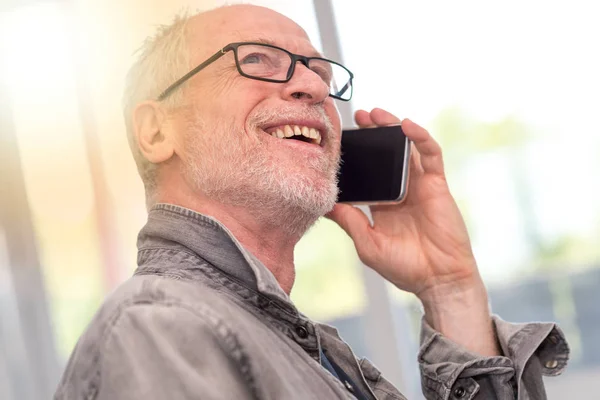 Porträtt av leende mogen man pratar telefon, ljuseffekt — Stockfoto