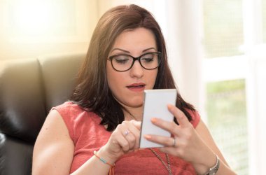 Güzel genç kadın cep telefonu ışık izlerken şaşırttı