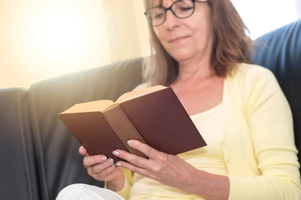Femme mûre lisant un livre, effet de lumière — Photo