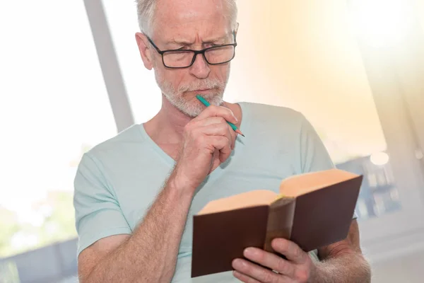 Okuma bir kitap, ışık efekti düşünceli olgun adam portresi — Stok fotoğraf