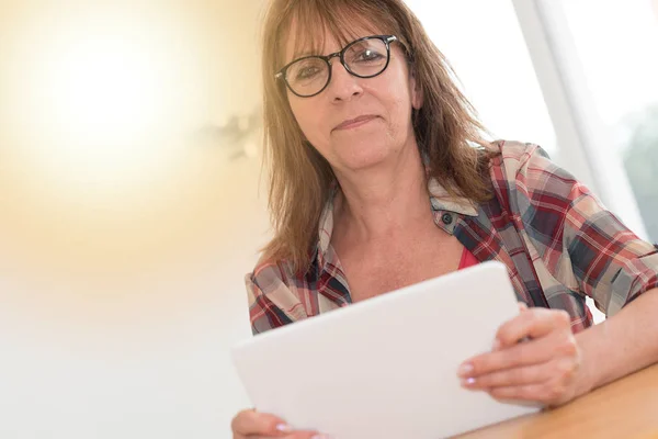 Femme mûre utilisant une tablette, effet de lumière — Photo