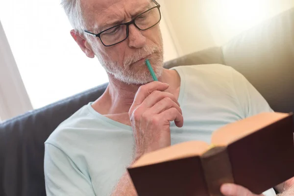 Πορτρέτο του στοχαστικός ώριμος άνδρας, διαβάζοντας ένα βιβλίο, την ελαφριά επίδραση — Φωτογραφία Αρχείου