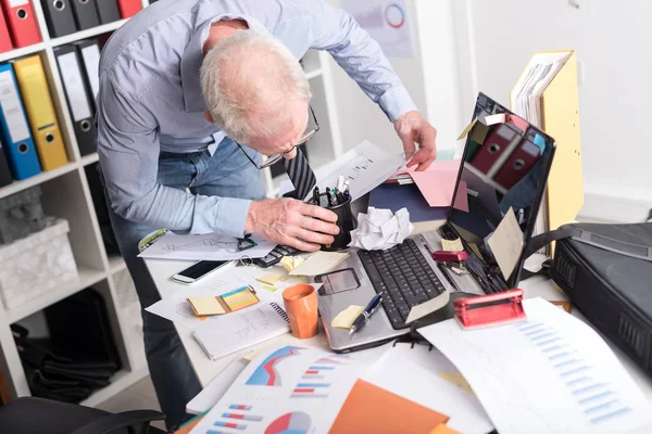 Uomo d'affari disorganizzato in cerca di documenti — Foto Stock