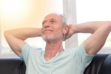 Olgun adam dinleme müzik kulaklık, ışık eff ile portresi