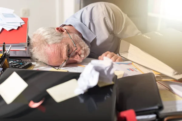 Überarbeiteter Geschäftsmann schläft auf einem chaotischen Schreibtisch, Lichteffekt — Stockfoto