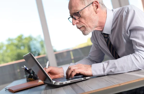 Volwassen zakenman met behulp van een laptop — Stockfoto