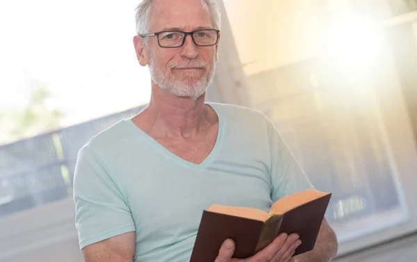 Πορτρέτο του ώριμος άνδρας, διαβάζοντας ένα βιβλίο, την ελαφριά επίδραση — Φωτογραφία Αρχείου