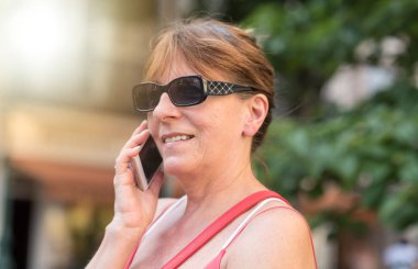 Kadın cep telefonunda güneşli bir günde, ışık etkisi söz