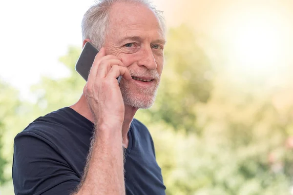 Portret van lachende volwassen man praten over telefoon, lichteffect — Stockfoto